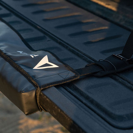ROAM Pickup Tailgate Pad in Marineblau mit Logo, Nahaufnahme der gepolsterten Ladeflächen-Schutzauflage mit Befestigungsgurten