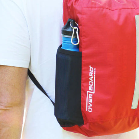 OverBoard wasserdichter Platzspar Rucksack in Rot, getragen auf der Schulter, mit Karabiner und Tragegriff, Seitenansicht