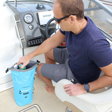 OverBoard Kühltasche hellblau, wasserdicht, Mann nutzt sie in Bootsumgebung, praktische Kühlbox für Outdoor