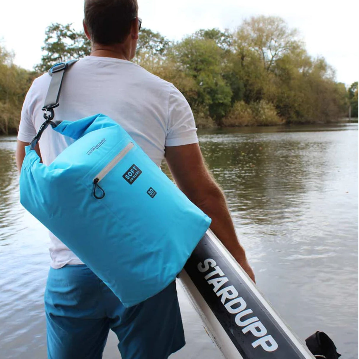 OverBoard Soft Cooler Bag in Blau, wasserdicht, getragen auf dem Rücken am Wasser, Frontalansicht