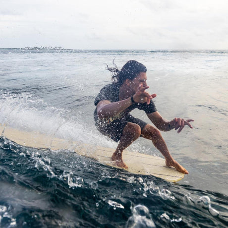 Surfer auf gelbem Torq TEC Delpero Classic Surfboard, riding a wave im Meer