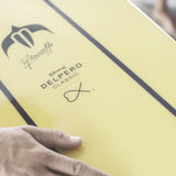 Torq TEC Delpero Classic Surfboard in Gelb mit Design-Logo und Unterschrift, Detailansicht des Decks