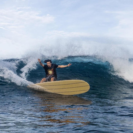 Torq Surfboard TEC Delpero Classic Gelb, Surfer auf gelbem Surfboard in Welle im Meer, Seitenansicht