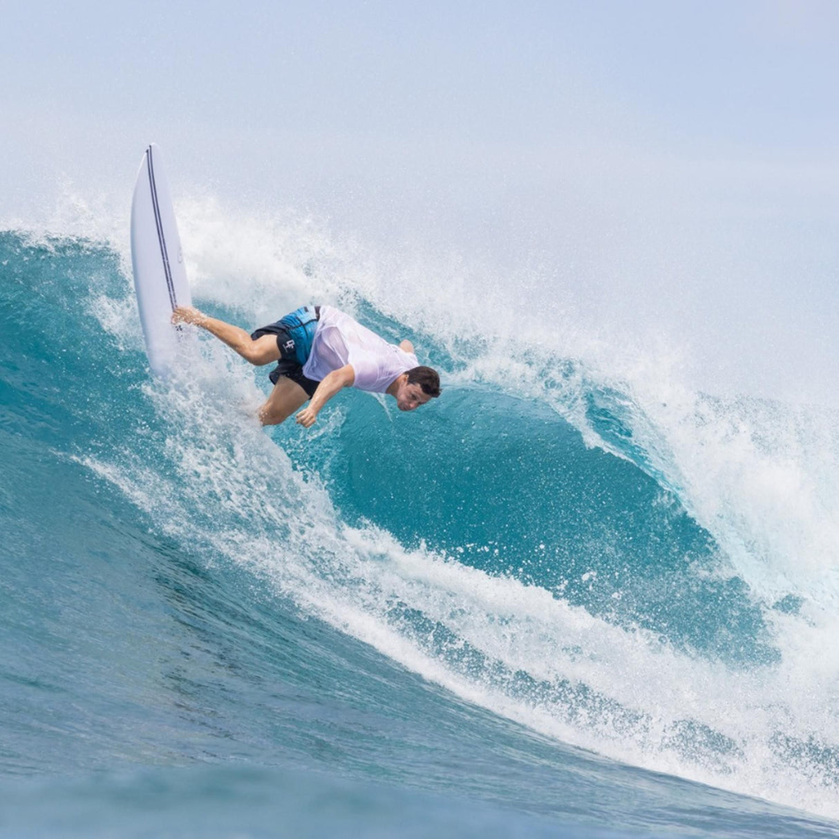 Torq TEC M2.0 Surfboard in Weiß, Surfer auf türkisfarbener Welle, Action-Perspektive