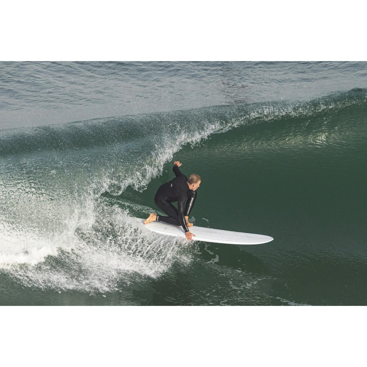 Torq TEC 24/7 Surfboard weiß mit orange Akzenten, Surfer in Aktion auf grüner Welle