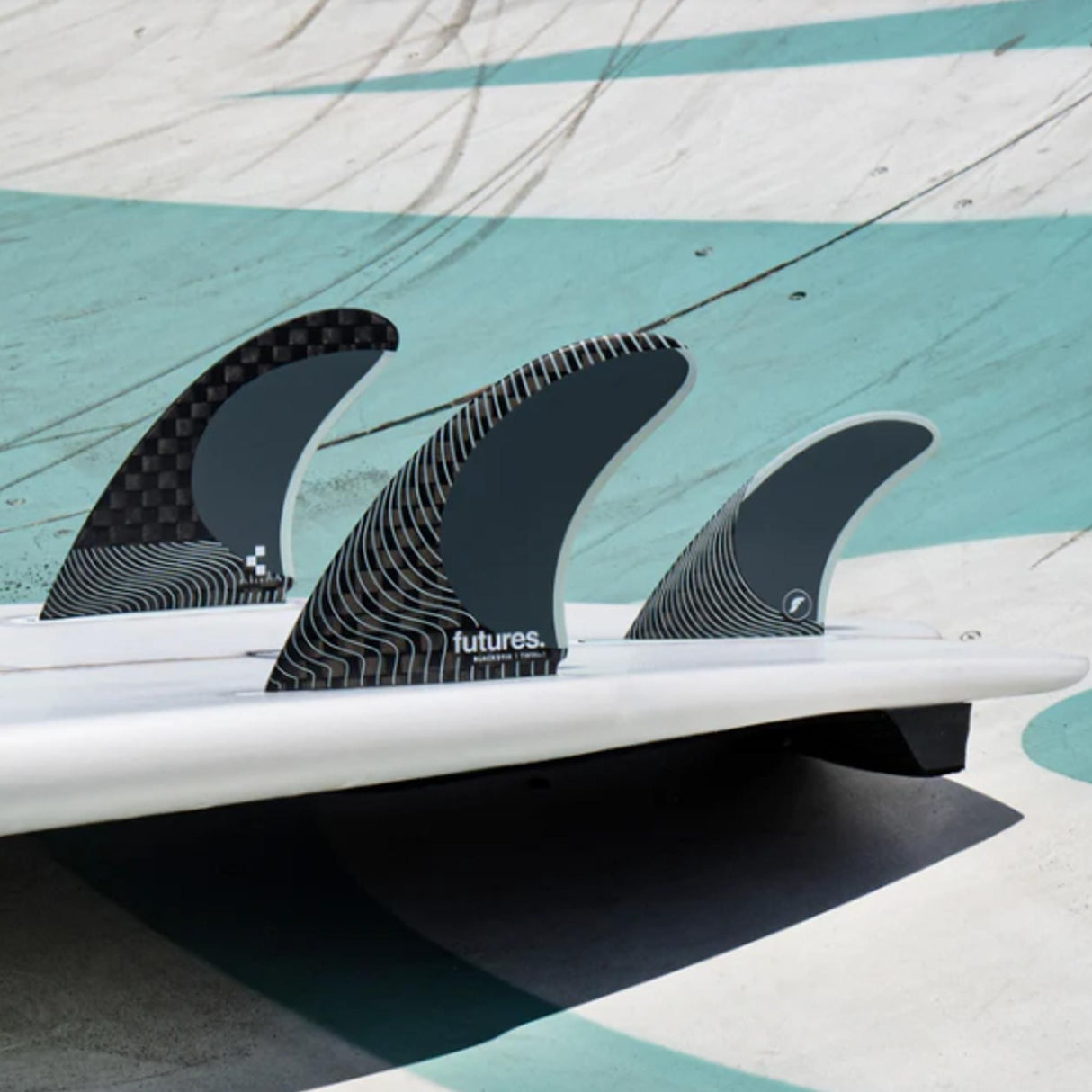 Futures Blackstix Twin +1 Finnen-Set, drei schwarze Surfboard-Finnen mit Rillen-Design auf weißem Brett, Draufsicht