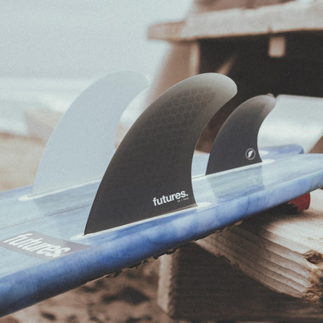 Futures Twin+1 Fin Set T1 Honeycomb, drei Surfflossen in Weiß und Schwarz auf blauem Surfboard, Honeycomb-Material, Draufsicht