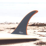 Futures Single Fin Tiller Fiberglass Finne in Grau und Orange, auf Surfboard am Strand montiert