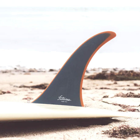 Futures Single Fin Tiller Fiberglass Finne in Grau und Orange, auf Surfboard am Strand montiert