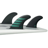 Futures Thruster Fin Set F6 Alpha, drei schwarze Flossen mit grünen Streifen auf Surfboard montiert