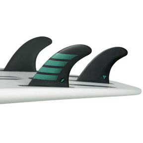 Futures Thruster Fin Set F6 Alpha, drei schwarze Flossen mit grünen Streifen auf Surfboard montiert