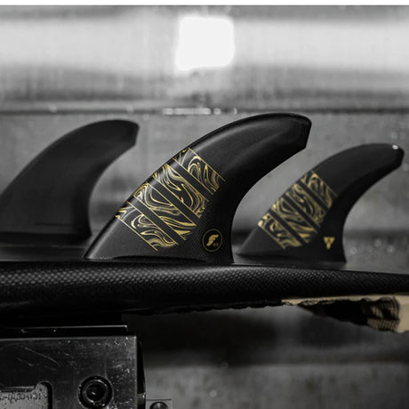 Futures Thruster Fin Set Vector 3/2 Alpha Medium schwarz mit goldenen Mustern, drei Flossen auf Board, Frontalansicht