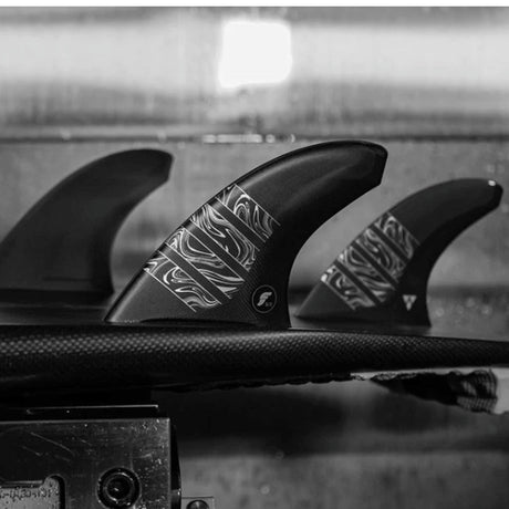 Futures Thruster Fin Set Vector 3/2 Alpha Large, schwarze Surfflossen mit weißem Muster auf Surfboard