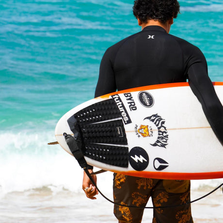 Futures Traction Pad Brewster Narrow schwarzes Rutschpad auf Surfboard, getragen am Strand