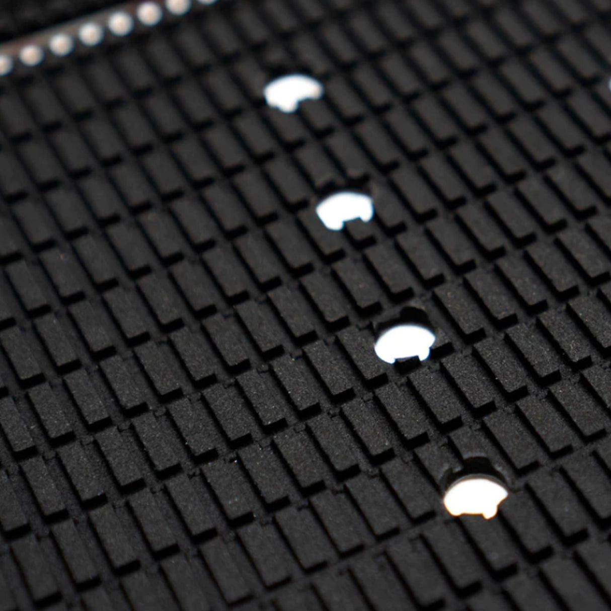 Futures Traction Landing Pad Surfboard Footpad schwarz mit Noppen und weißen Befestigungslöchern, Nahaufnahme