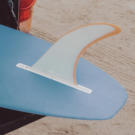 Futures Single Fin Zack Flores Fiberglass weiß-orange auf blauem Surfboard, Draufsicht am Strand