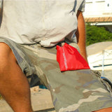 OverBoard wasserdichter Beutel in Rot, in Hand gehalten, mit Verschlussband, perfekt für Wassersport und Outdoor-Aktivitäten