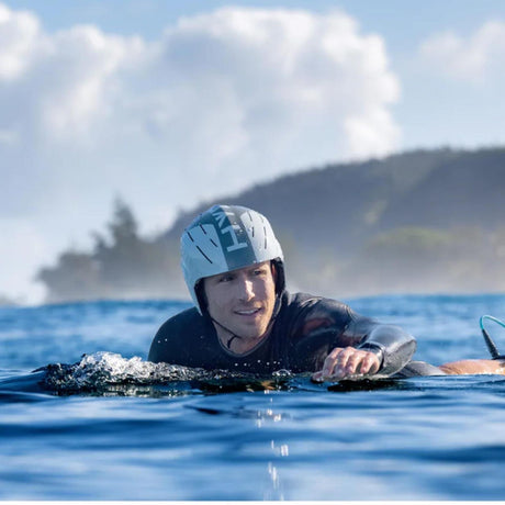 HYDA Coanda Fusion Wassersport Helm in Weiß-Blau, getragen von Surfer im Wasser, leichte Konstruktion mit Belüftungslöchern