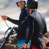 HYDA Coanda Core Wassersport Helm weiß und schwarz, zwei Wassersportler mit Helmen und Neoprenanzügen beim Kitesurfen am Strand