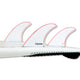 Futures Thruster Fin Set Jordy Smith Honeycomb mit drei roten und weißen Flossen auf weißem Surfboard, Seitenansicht