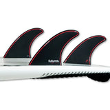 Futures Thruster Fin Set Jordy Smith Honeycomb, schwarze Flossen mit rotem Rand auf weißem Surfboard, Honeycomb-Material, Frontalansicht