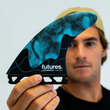 Futures Thruster Fin Set Jack Robinson Honeycomb, blau-schwarzes Design mit Wabenstruktur, in Hand gehalten