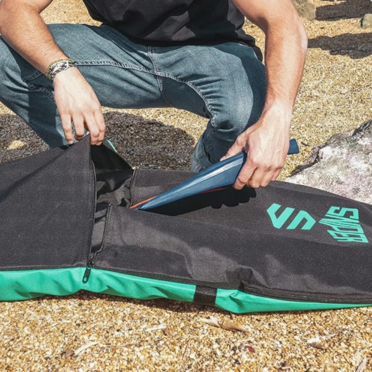 Sniper Bodyboard Rucksack Single Cover in Schwarz mit Grün, Person öffnet Reißverschluss am Strand