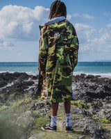 Dryrobe Advance Long Sleeve in Camouflage, Rückansicht am Strand getragen