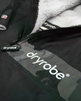 DRYROBE Advance Kurzarm in Schwarz mit weißem Fleece-Futter, Detailansicht des Reißverschlusses und Logo