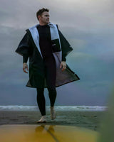 DRYROBE Advance Kurzarm in Schwarz mit hellblauem Fleece-Futter, Mann am Strand tragend