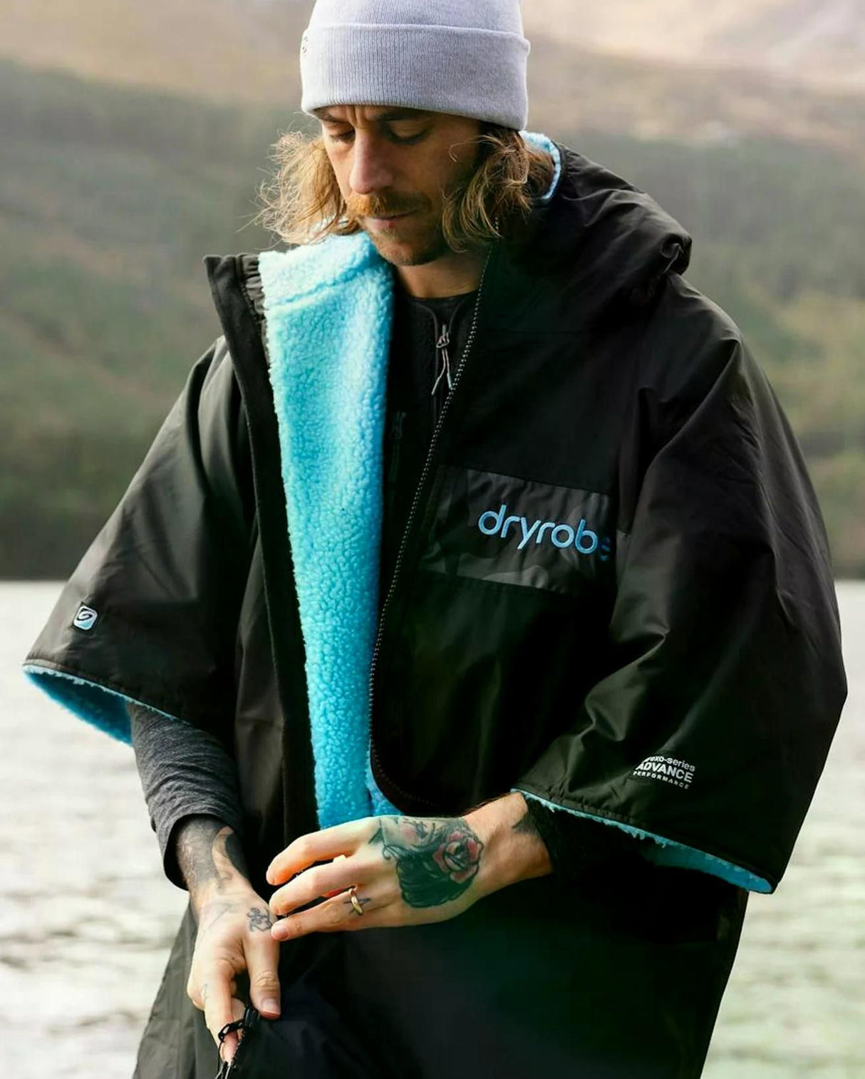 DRYROBE Advance Kurzarm in Schwarz mit türkisem Fleece-Futter, Frontansicht getragen am See
