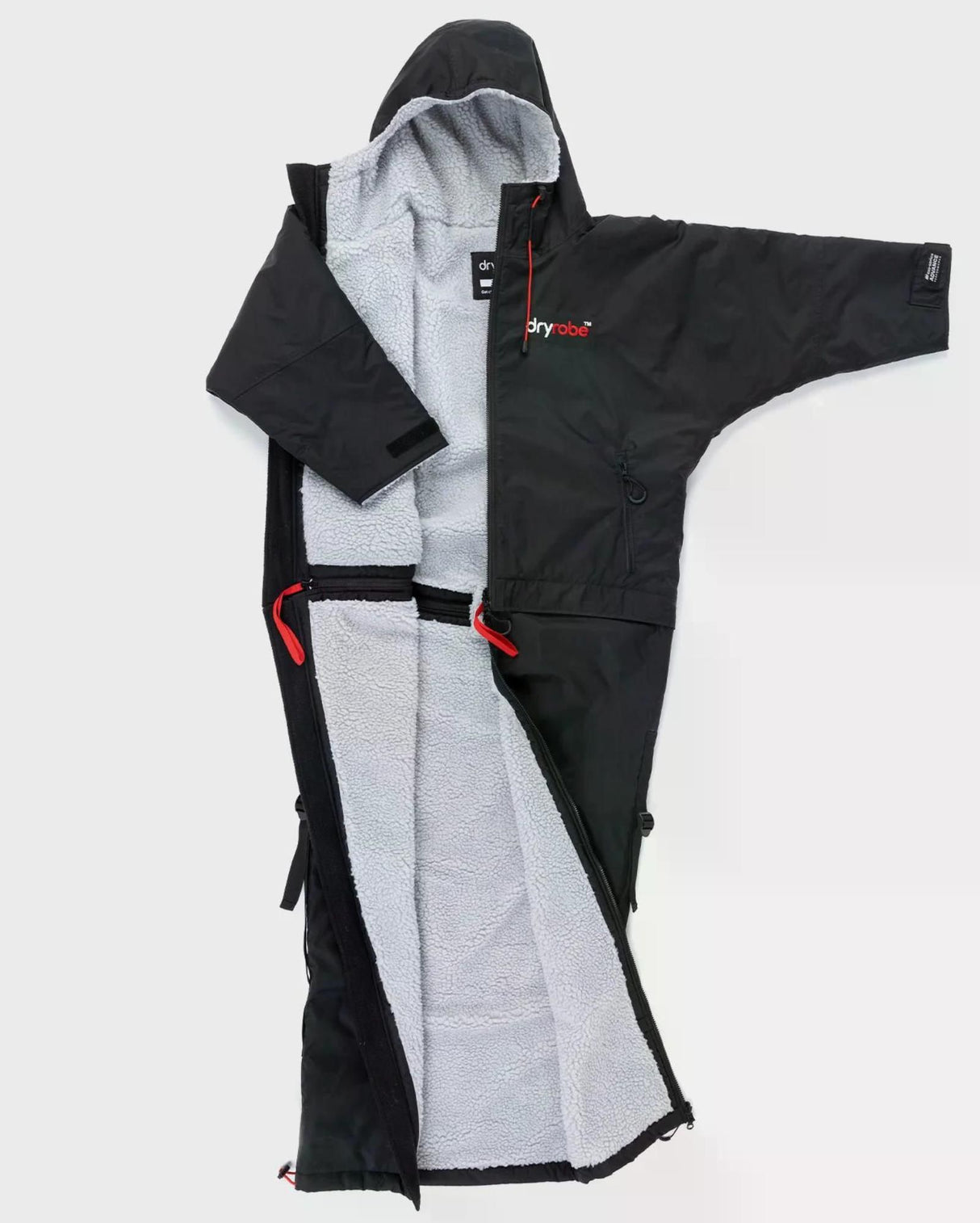 Dryrobe Adapt Mantel in Schwarz mit grauem Fleece-Futter, ausgebreitet von vorne, mit roten Riemen und funktionalen Details