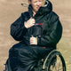 Dryrobe Adapt Mantel schwarz, tragbar im Sitzen, wasserdicht, Person im Rollstuhl am Strand