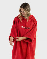 Dryrobe Handtuchmantel aus Bio-Baumwolle in Rot, getragen von einer Frau, Vorderansicht