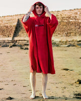 Dryrobe Handtuchmantel aus Bio-Baumwolle in Rot, getragen am Strand, mit Kapuze und Logo-Print
