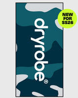Dryrobe Strandtuch in Dunkelblau mit weißem Logo und abstraktem Wellenmuster, Frontalansicht der Produktverpackung