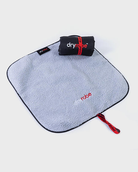 Dryrobe Umziehmatte aus hellblauem Mikrofaser-Handtuch mit dunkelblauem Rand, kompaktem schwarzen Transportbeutel und rotem Griff