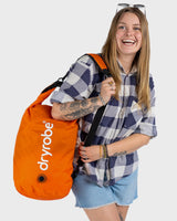 Dryrobe wasserdichter Packsack Drybag in Orange mit weißem Logo, von einer Frau getragen