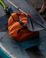 Dryrobe Drybag wasserdichter Packsack orange mit schwarzen Riemen auf Boot, Detailansicht