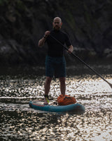 Dryrobe wasserdichter Packsack Drybag in Orange auf Stand-Up-Paddleboard beim Wassersport