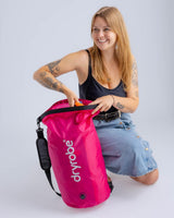 Dryrobe wasserdichter Packsack Drybag in Pink, von Frau gehalten, mit Schultergurt und Rollverschluss