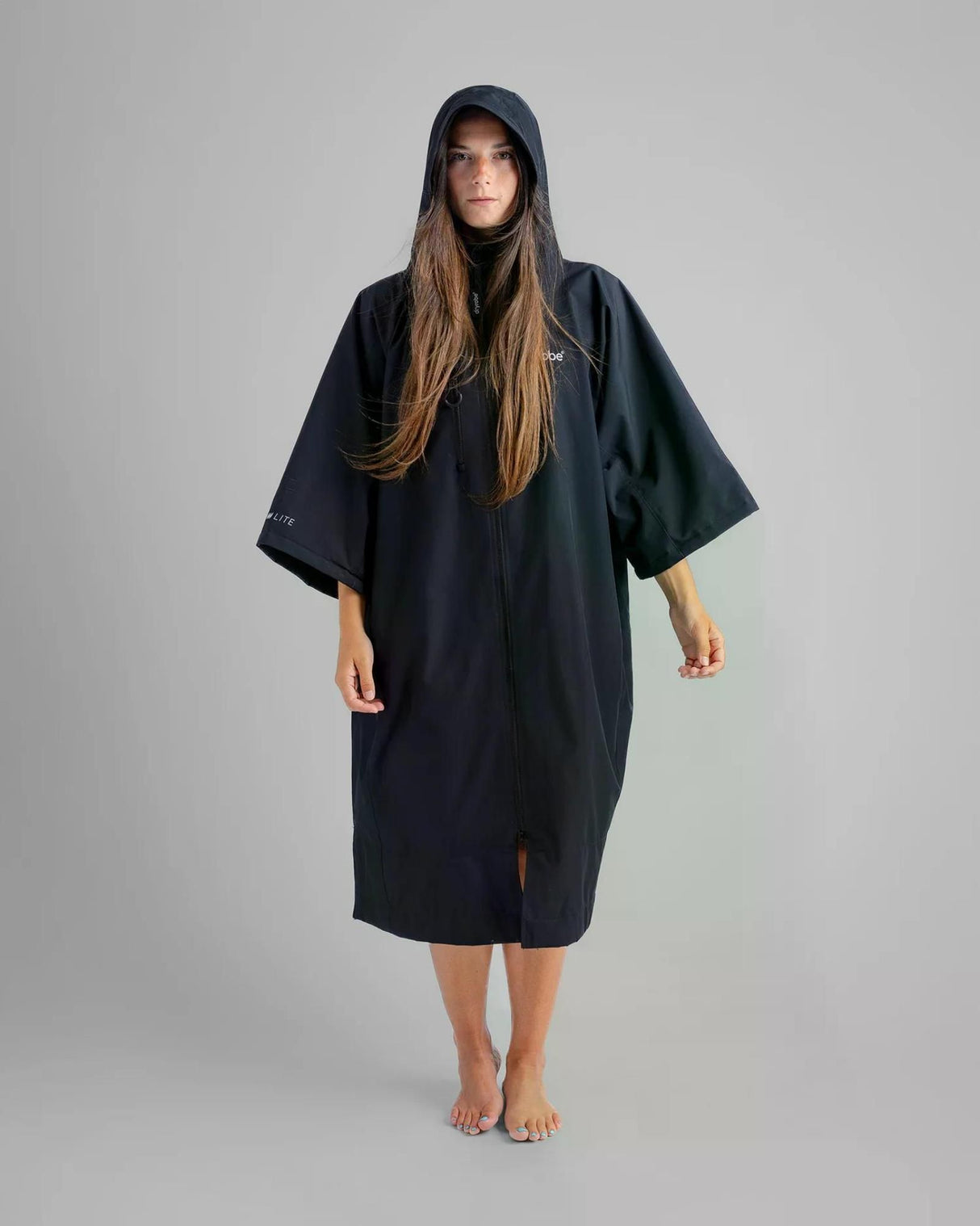 Dryrobe Tech-Lite Kurzarm Umhang in Schwarz, Frontansicht auf Model, leichte atmungsaktive Materialien mit Kapuze