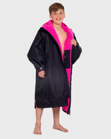 Dryrobe Advance Long Sleeve Kids in Schwarz und Pink, Wechselrobe mit Fleece-Innenseite, Frontansicht auf Kind