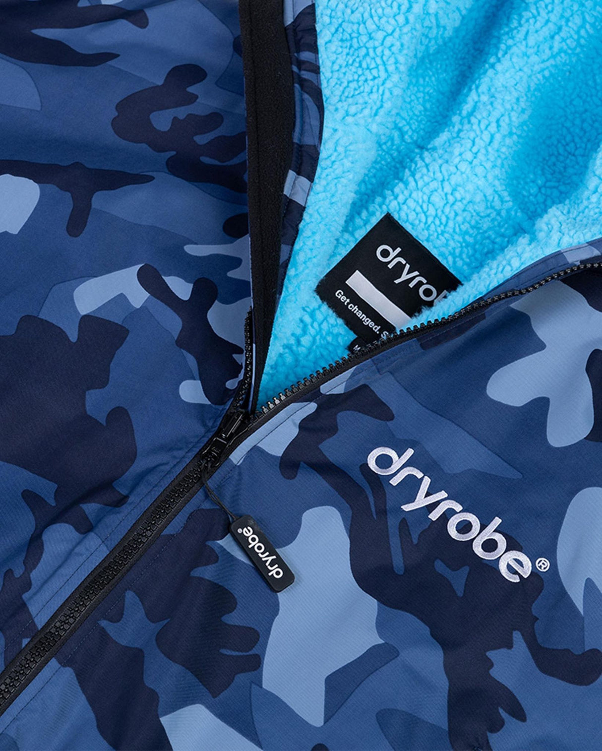 Dryrobe Advance Kinder Langarmrobe in Blau-Camouflage mit türkisfarbenem Fleece-Innenfutter, Detailaufnahme des Reißverschlusses und Etiketts