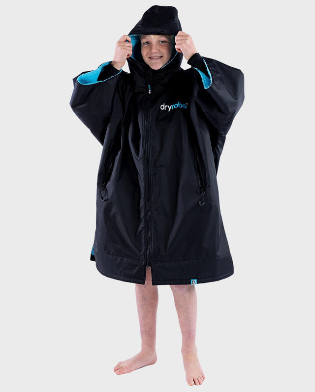 Dryrobe Advance Short Sleeve Kids in Schwarz mit Blau, Kapuzenpullover aus Neopren, Frontansicht auf Kind