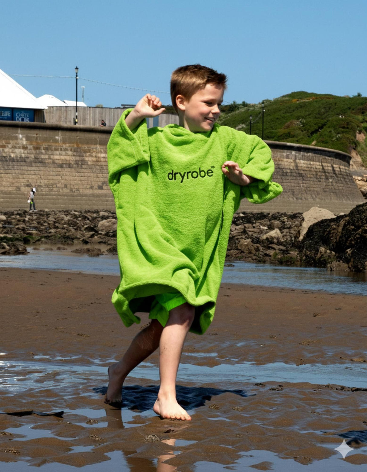 Dryrobe Kids Towel Robe Bio in Neongrün, Junge am Strand tragend, Bio-Material, Frontalansicht