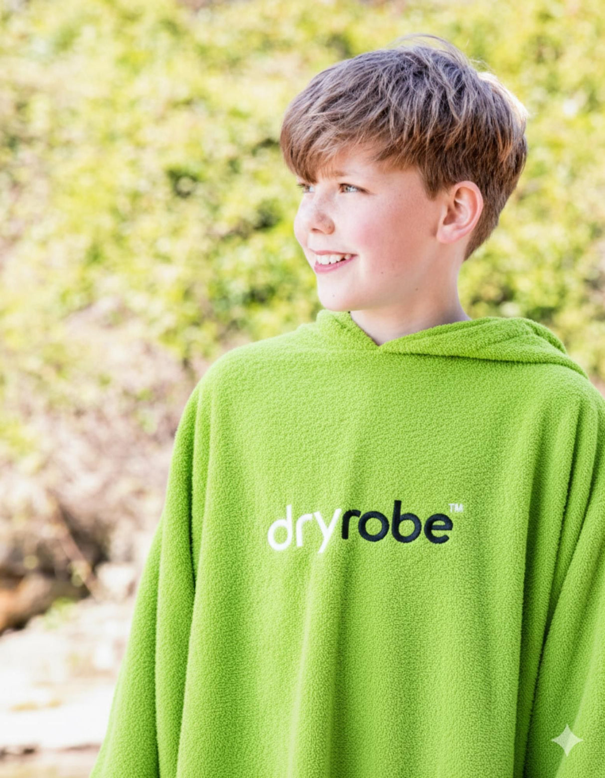 Dryrobe Kids Towel Robe Bio in Grün, getragen von Kind von hinten, Bio-Baumwollmaterial mit Kapuze