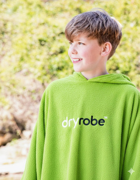 Dryrobe Kids Towel Robe Bio in Grün, getragen von Kind von hinten, Bio-Baumwollmaterial mit Kapuze