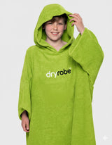 Dryrobe Kids Towel Robe Bio in Limone, Kind trägt grünen Bademantel mit Kapuze und dryrobe-Logo, Frontalansicht