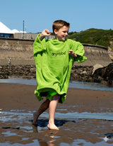 Dryrobe Kids Towel Robe Bio in Neongelb, Junge am Strand tragend, Bio-Baumwolle, Frontansicht